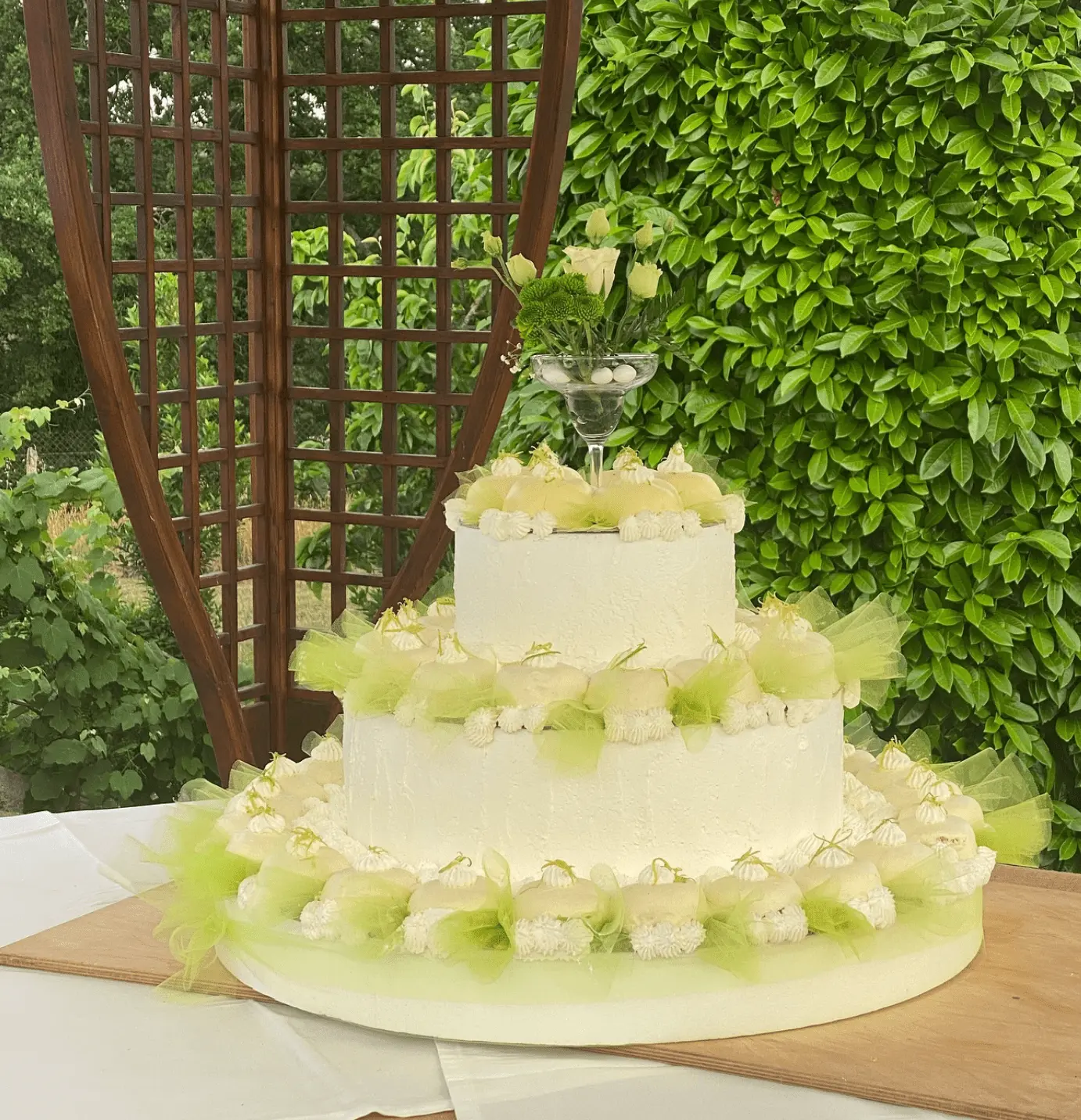 Beautiful wedding cake with green ribbon details in garden setting