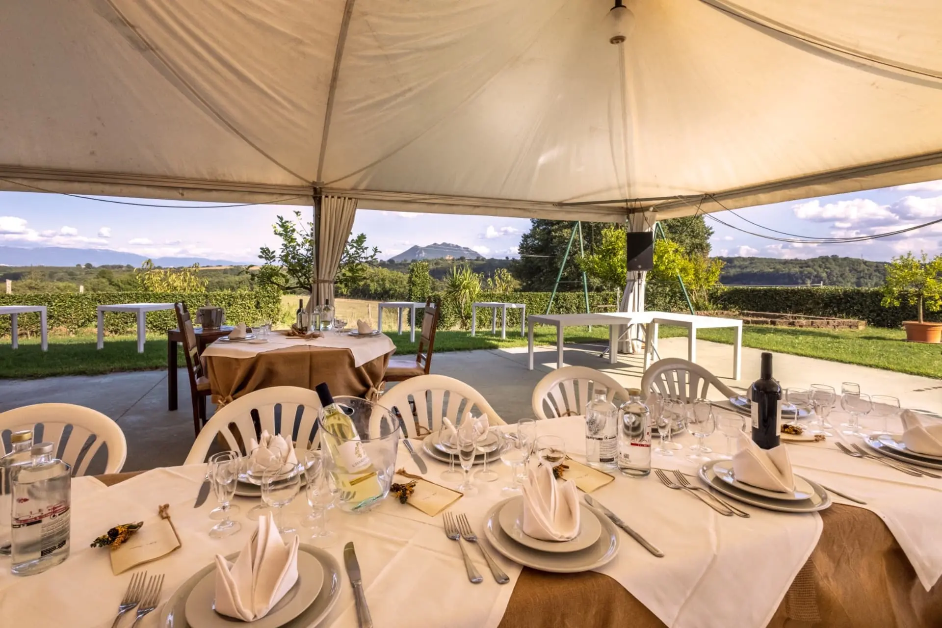 Elegant outdoor dining setup under tent with mountain views